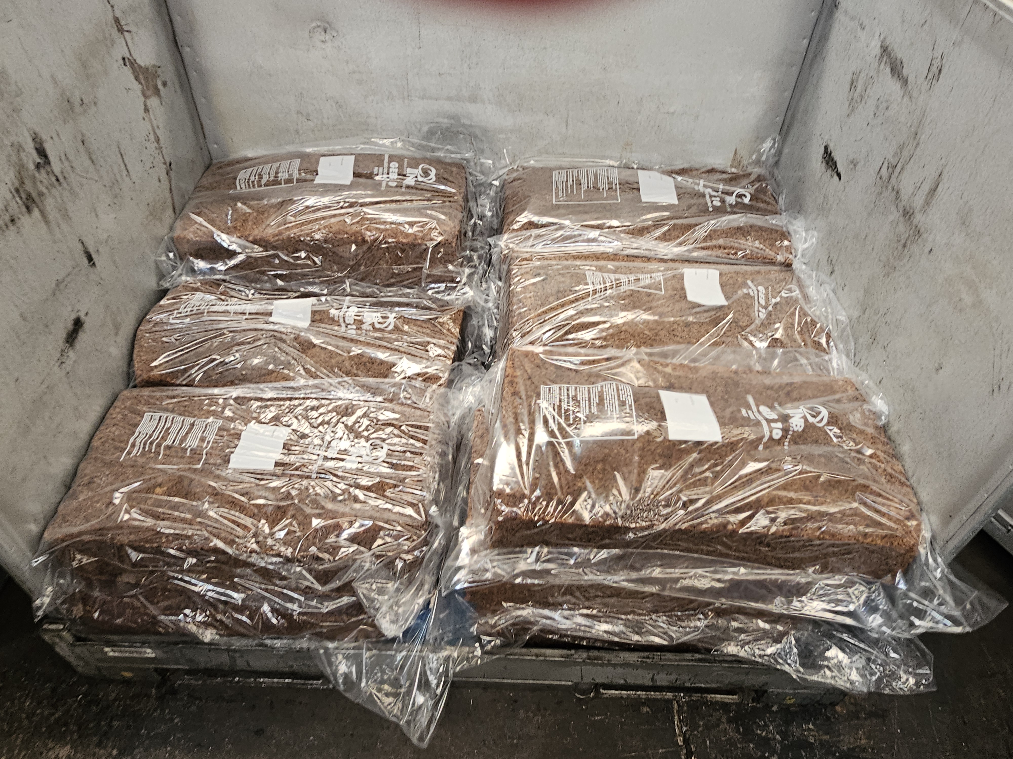 Fardos de GEB-10 sendo encaixotados na caixa metálica para transporte.