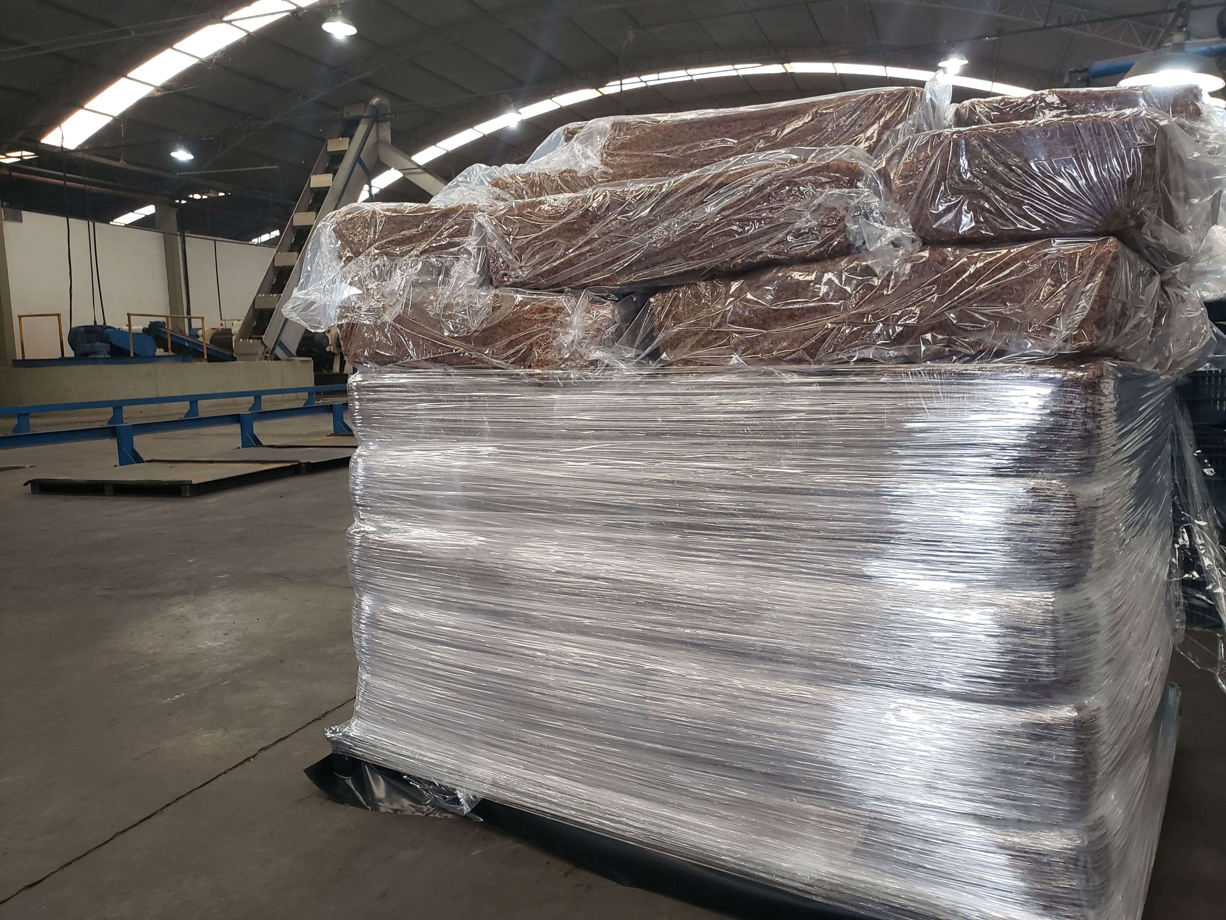 Fardos de GEB-10 sendo embalados para transporte em palete.